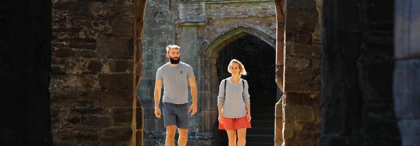 Castell Rhaglan / Raglan Castle visitors entering a doorway